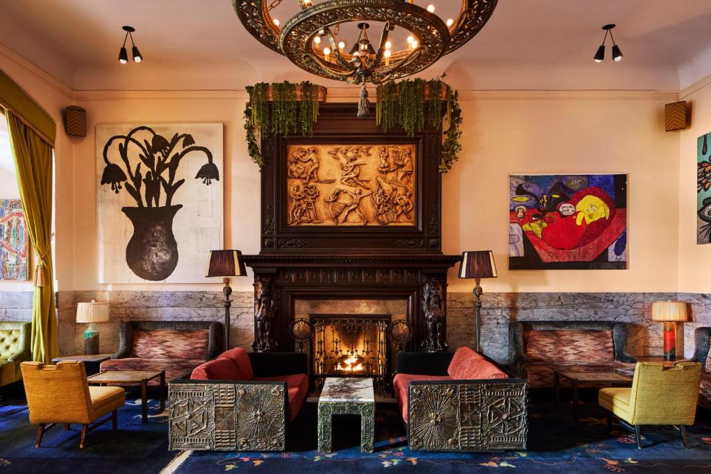 Hotel lounge with a fireplace, red sofas and paintings