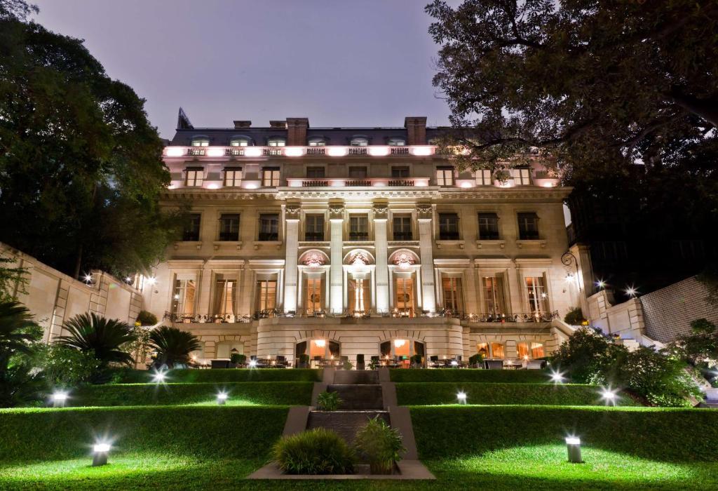 Illuminated palace hotel above a terraced garden at dusk