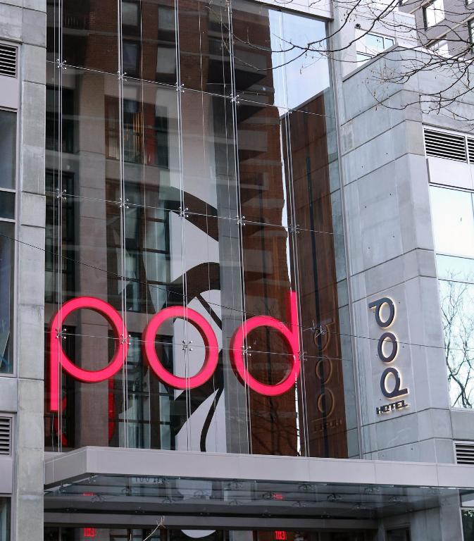 Pod Hotel glass facade with a red neon sign